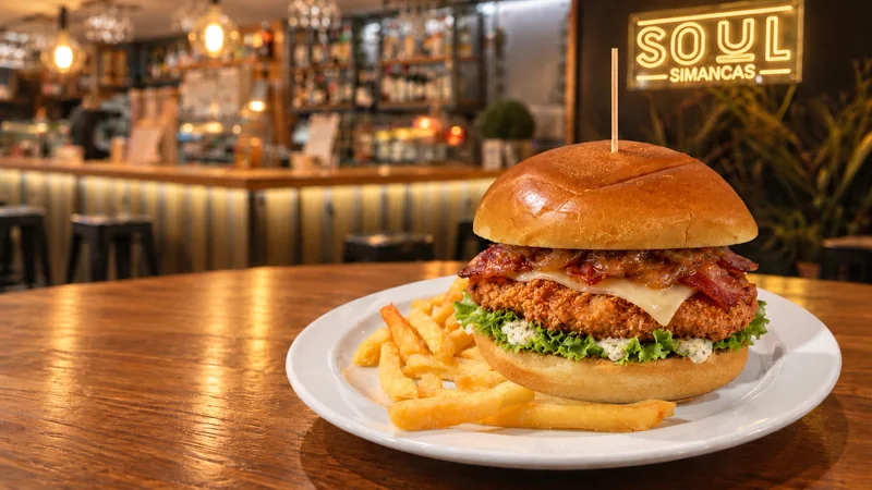 Hamburguesa Simancas de pollo crujiente con patatas fritas.